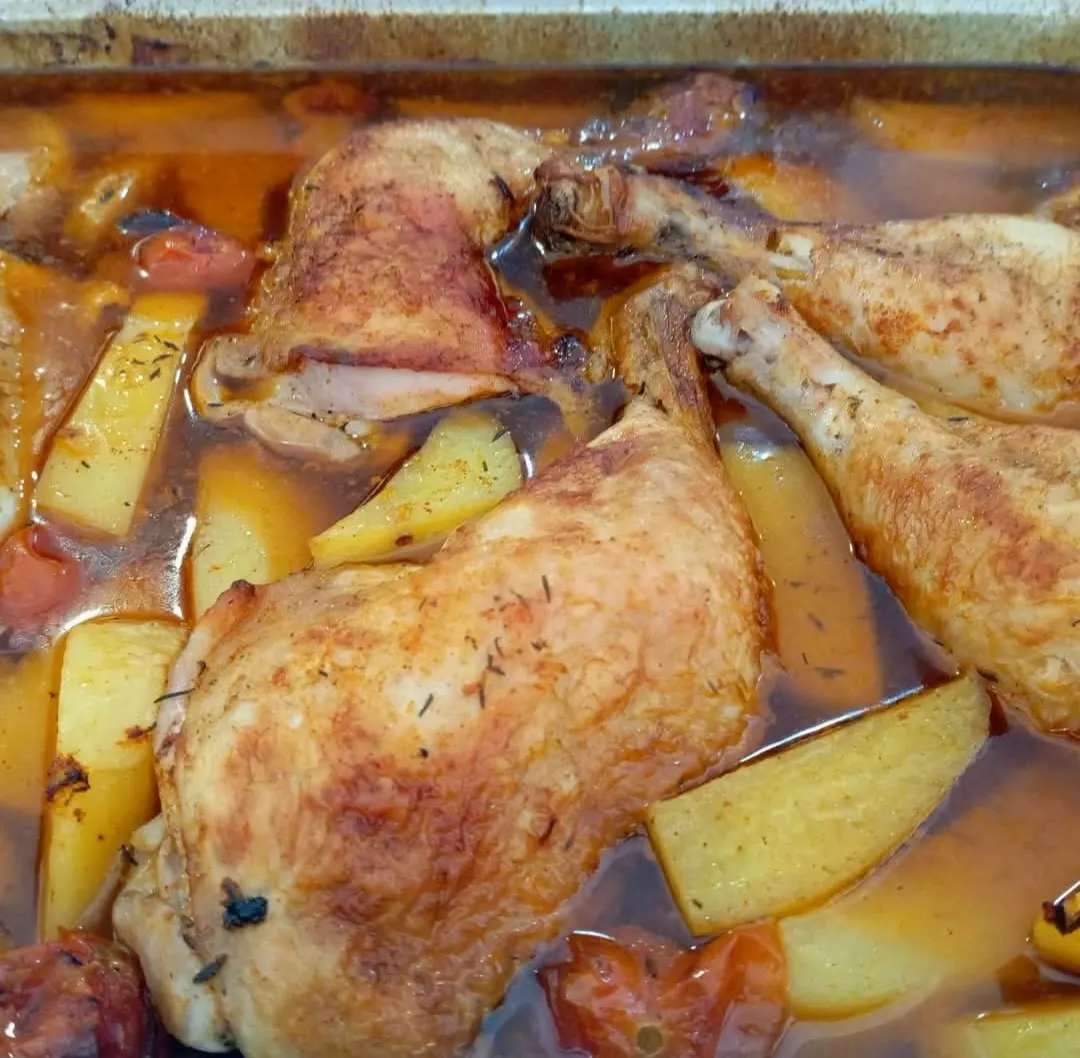 Pollo asado con patatas en una bandeja de horno de El Togo
